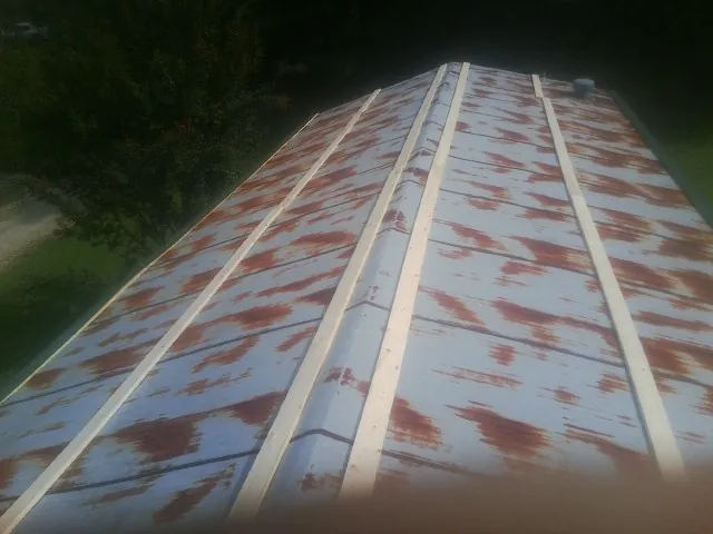 Rusted metal roof panels with new wood purlins before replacement — Storm Damage Roof Repair in Saint Louis by Roofing Brothers